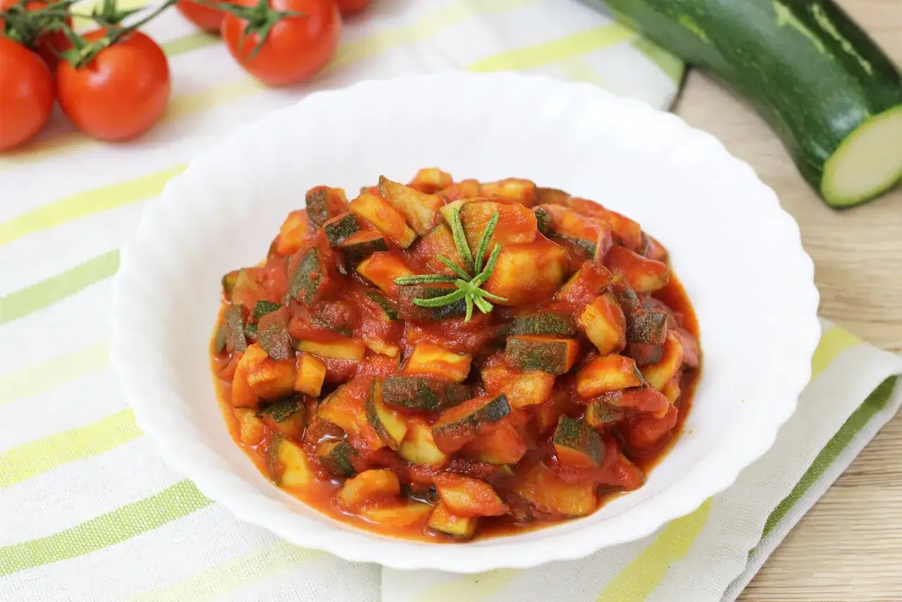 Piatto di zucchine in umido con pomodoro e rosmarino, contorno fresco e saporito.
