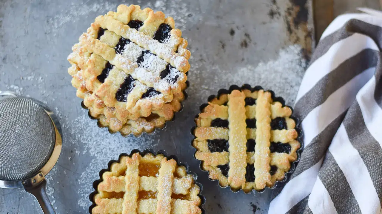 Deliziose crostatine con pasta frolla all'olio, ripiene di marmellata, spolverate di zucchero a velo.
