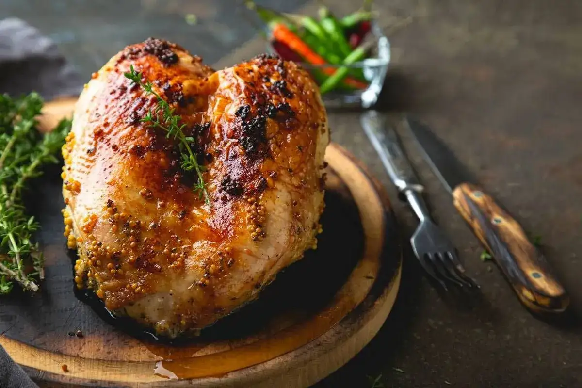 Succulento petto di pollo al forno, dorato e speziato, pronto per essere gustato con erbe aromatiche e peperoncini.
