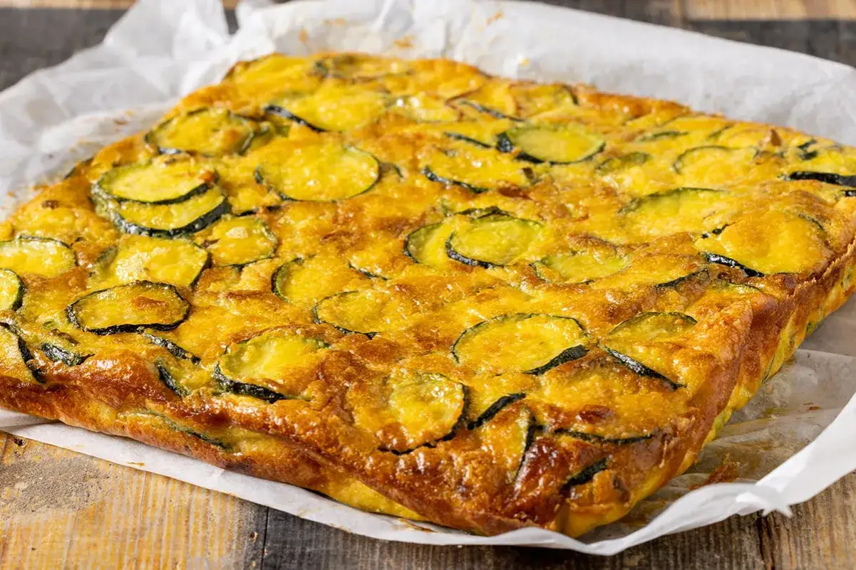 Frittata di zucchine dorata e invitante, con fette di zucchine ben visibili sulla superficie, pronta per essere gustata.