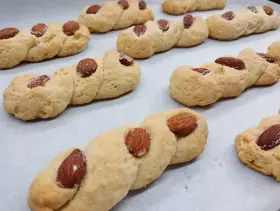 Intorchiate pugliesi ricetta originale: biscotti intrecciati dorati con mandorle e zucchero, pronti per essere gustati.