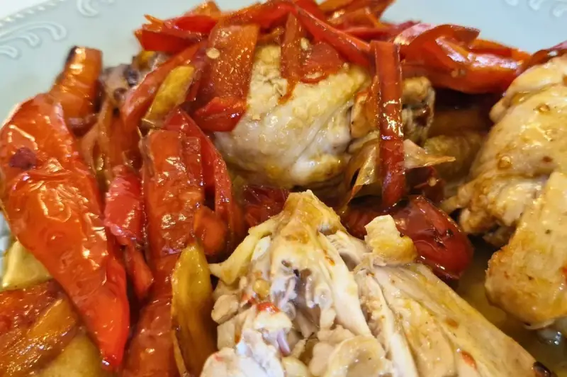 Succulento pollo alla romana con peperoni rossi arrostiti, un piatto saporito e colorato.